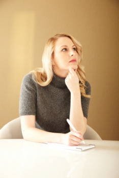 photo shows a job seeker thinking about her list of actions she needs to do to find a new job